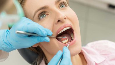 Woman gets teeth professionally cleaned by dentist