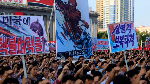 Tens of thousands of North Koreans gathered for a rally at Kim Il Sung Square carrying placards and propaganda slogans as a show of support for their rejection of the United Nations' latest round of sanctions on Wednesday Aug. 9, 2017, in Pyongyang, North Korea. (AP Photo/Jon Chol Jin)