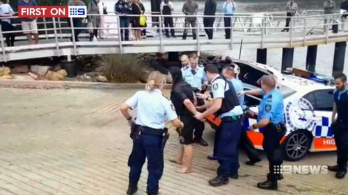 The woman was pulled from the water by police officers. (9NEWS)