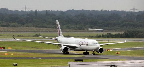 The Qatar Airways plane taxis into Manchester Airport after a bomb threat forced an emergency landing. (AAP)