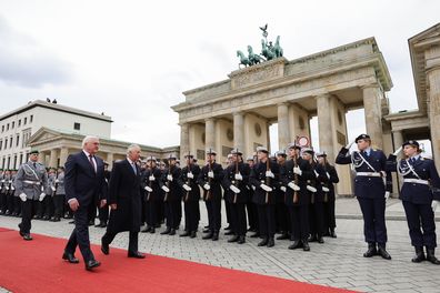 German President Frank-Walter Steinmeier and King Charles III walk together in front of the military Guard of Honour and Brandenburg Gate during the Ceremonial welcome at Brandenburg Gate on March 29, 2023 in Berlin, Germany. 