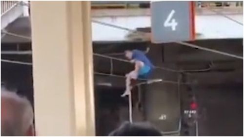 Train commuters have faced lengthy delays after a man was filmed standing on overhead wires at Redfern station.