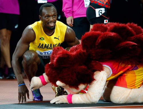 Bolt smiles next to mascot Hero the Hedgehog after his men's 100m heat the World Athletics Championships. (Image: AP Photo/Matthias Schrader)