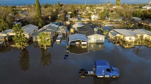 Following days of rain, floodwaters surround homes and vehicles in the Planada community of Merced County, Calif., on Tuesday, Jan. 10, 2023. 