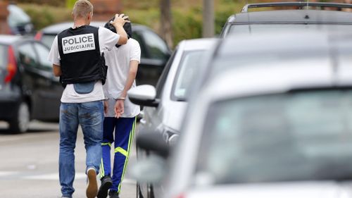 A French policeman arrests a man following a search of a house in the Normandy city of Saint-Etienne-du-Rouvray. (AFP)