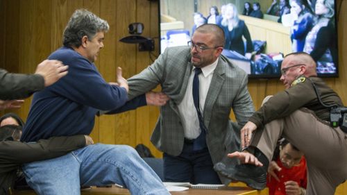 Randall Margraves, father of three victims of Larry Nassar, lunges at the serial child molester. (AAP)