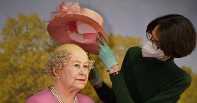 The wax figure of Queen Elizabeth II is bald underneath her hat.