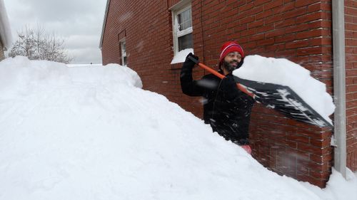 Patrick Harden clears snow from the roof of his car on in Erie, Pa. The National Weather Service office in Cleveland says Monday's storm brought 34 inches of snow, an all-time daily snowfall record for Erie. Another 19 inches fell before dawn Tuesday, making the greatest two-day total in commonwealth history. (Greg Wohlford/Erie Times-News via AP)