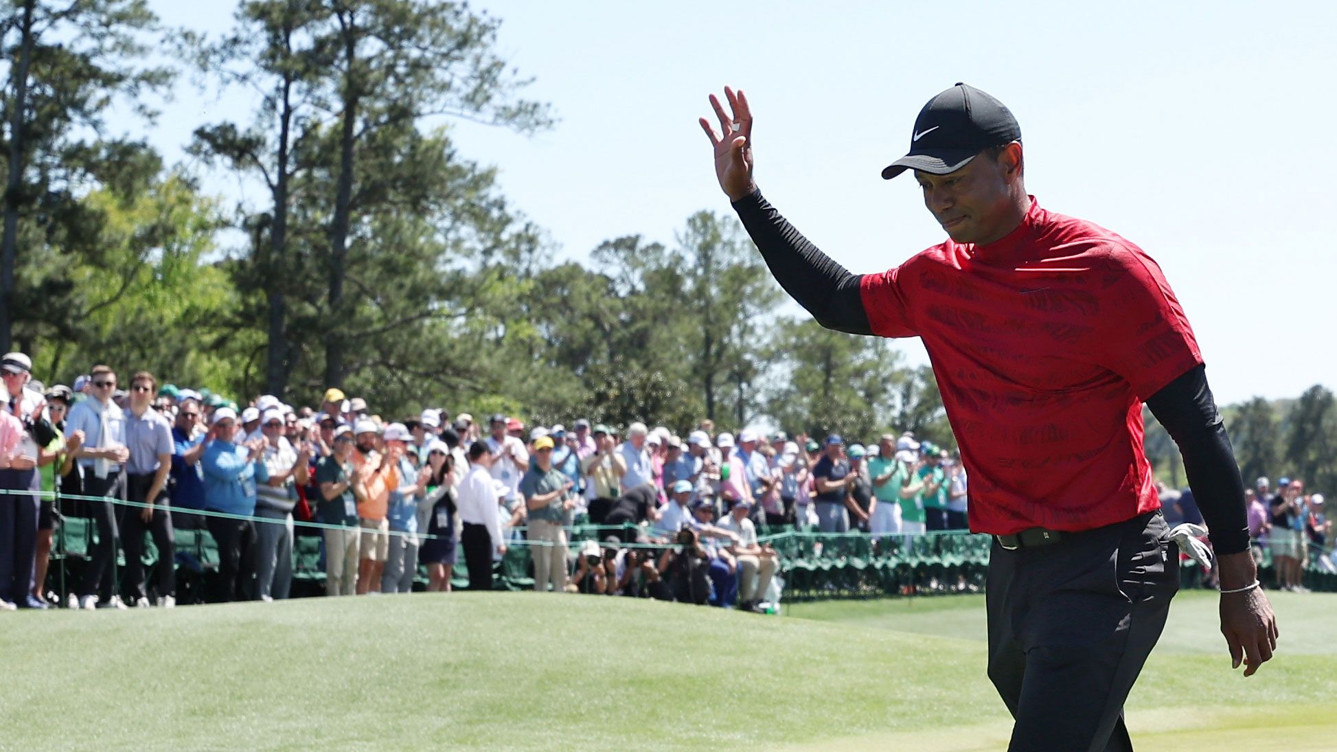 Tiger Woods waves to the crowd on the 18th green after finishing his round during the final round of the Masters.