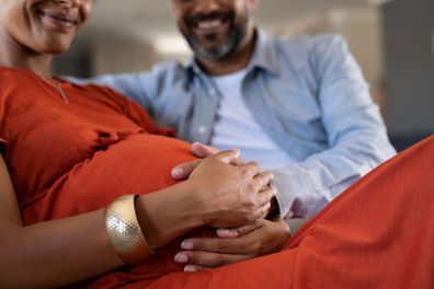 Pregnant couple on sofa