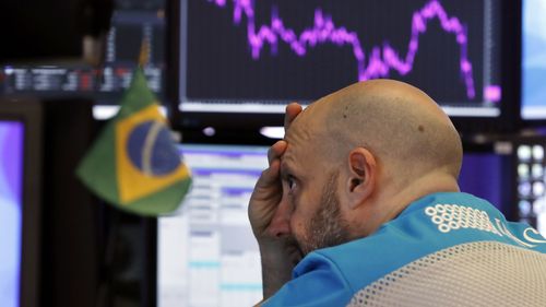 Worker at his post on the floor of the New York Stock Exchange, as stocks slumped and bond prices soared for the second day in a row.