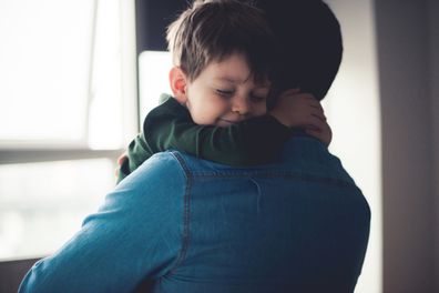 Dad and cute little son sharing an emotional hug.