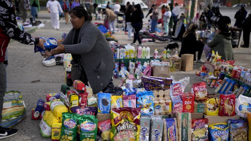 A vendor completes a transaction at a market where people can buy or barter goods, on the outskirts of Buenos Aires, Argentina, Wednesday, Aug. 10, 2022. Argentina has one of the worlds highest inflation rates, currently running at more than 60% annually, according to the National Institute of Statistics and Census of Argentina (INDEC).  (AP Photo/Natacha Pisarenko)