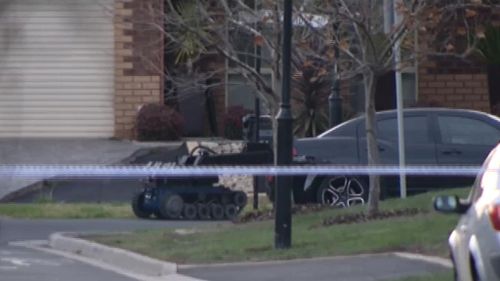 A bomb squad robot examines the device under the car. (9NEWS)