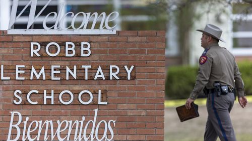 Un soldat de l'État passe devant le panneau de l'école élémentaire Robb à Uvalde, au Texas, à la suite d'une fusillade meurtrière à l'école.