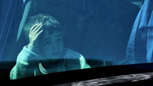 A child looks on aboard a bus as Australian nationals evacuated from Lebanon arrive at Larnaca International Airport on October 5, 2024 in Larnaca, Cyprus. 