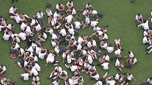 Students huddled on the school's oval after the fire. (9NEWS)
