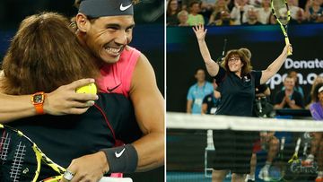 Rafael Nadal of Spain gives Deb, a firefighter a hug after she played on court.