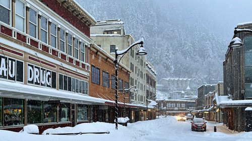 Um carro passa por uma rua principal nevada no centro de Juneau, Alasca, segunda-feira, 29 de dezembro de 2025. (AP Photo / Becky Bohrer)