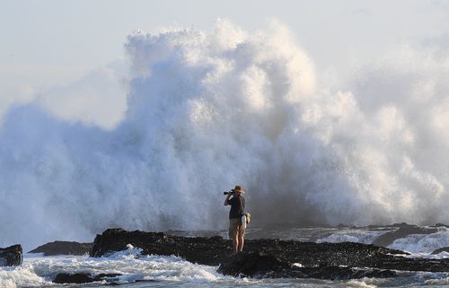 A photographer observes surf conditions at Snapper Rocks on the Gold Coast. (AAP)