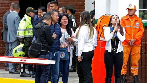 Family members of victims of the bombing gather outside the entrance to the General Santander police academy where the bombing took place in Bogota, Colombia.