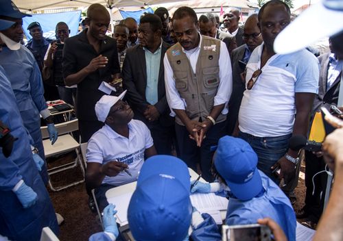 Congo's Health minister Oly Ilunga (seated centre) speaks with other workers during the launch of an experimental Ebola vaccine in Mbandaka, north-western Democratic Republic of the Congo. (AAP)