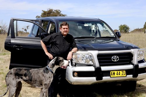 Father Chris Riley, his two dogs and car in 2009.