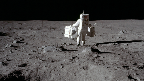 In this July 20, 1969 photo made available by NASA, lunar module pilot Buzz Aldrin carries a seismic experiments package in his left hand and the Laser Ranging Retroreflector to the deployment area on the surface of the moon at Tranquility Base.  (Neil Armstrong/NASA via AP)