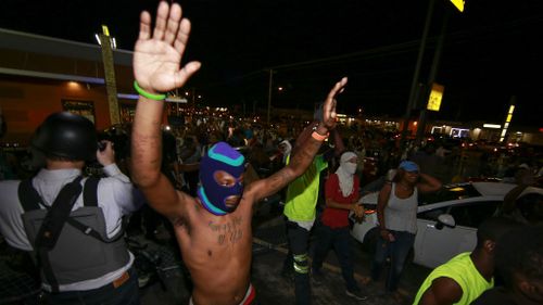 Demonstrators raise their hands during a rally on West Florissant Avenue. (Getty Images)