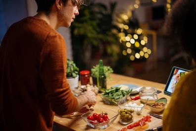 Happy young couple preparing homemade pizza for Christmas dinner at home. Multiracial couple spending time together at home, preparing dinner
