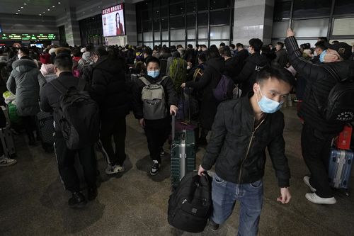 Travelers with their luggage arrive at a departure hall to catch their trains at the West Railway Station in Beijing