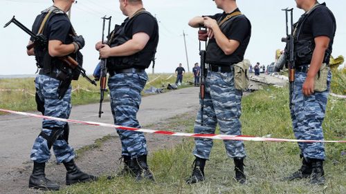 Armed pro-Russian rebel soldiers guard the MH17 crash site in Ukraine. (AAP)