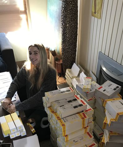 Priscilla Hajiantoni surrounded by Bang'n Body orders in her mum's living room.