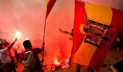Right-wing extremists burnt pro-independent Catalan flags during a protest on Spain's national day. (Photo: AAP).