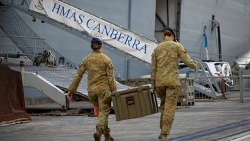 Australian Army personnel load stores onboard HMAS Canberra alongside Garden Island Defence Precinct, NSW.