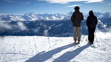 Skiers overlooking the Swiss Alps Switzerland