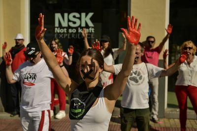 Demonstrators with red painted hands take a stand