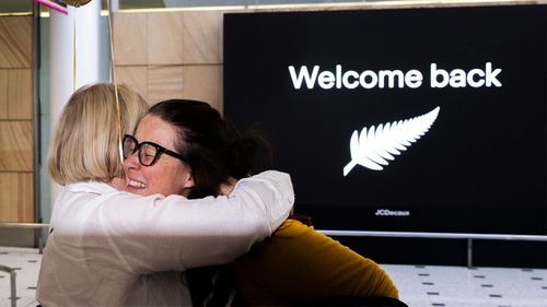 New Zealand travellers embrace at Sydney International Airport.