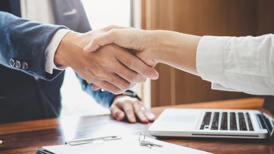 Real estate agent and customers shaking hands together celebrating finished contract after about home insurance and investment loan, handshake and successful deal.