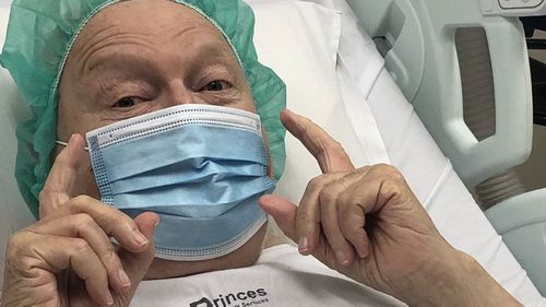 A masked Bert Newton in his hospital bed.