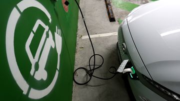 A Hyundai Kona Electric charges at a EV charge station