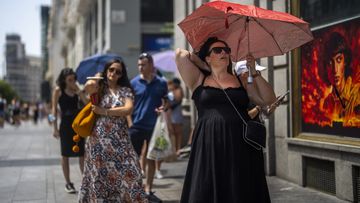 A woman holds an umbrella to shelter from the sun during a hot sunny day in Madrid, Spain, July 18, 2022. 