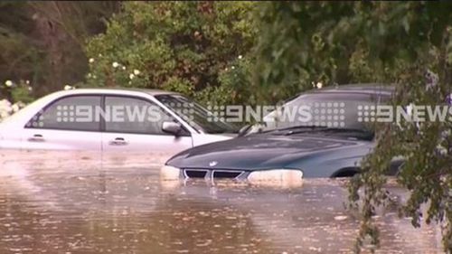 Cars and houses are submerged in water. (9NEWS)