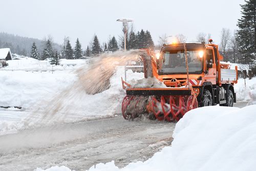 A slow blower cleans snow from a street in Lofer, Salzburg, Austria, which has seen three fatalities on its slopes.