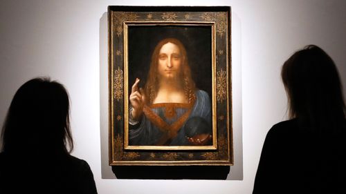 People gather around Leonardo da Vinci's "Salvator Mundi" on display at Christie's auction rooms in London, in 2017.