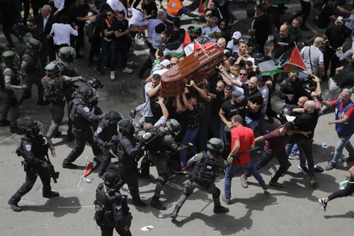 Israeli police confront with mourners as they carry the casket of slain Al Jazeera veteran journalist Shireen Abu Akleh during her funeral in east Jerusalem, Friday, May 13, 2022. Abu Akleh, a Palestinian-American reporter who covered the Mideast conflict for more than 25 years, was shot dead Wednesday during an Israeli military raid in the West Bank town of Jenin. (AP Photo/Maya Levin)