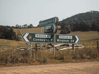 Road signs at an intersection of an unsealed gravel road at Comboyne, New South Wales. The intersection of Colling Road and Wingham Road.