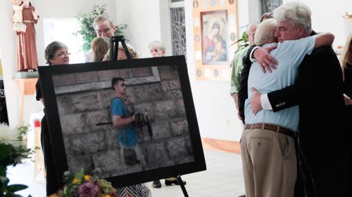 Foley's father John embraces a mourner at a memorial service for his slain son in August. (AAP)