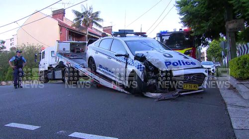 Two police officers have been hurt in Sydney after slamming their car into a building