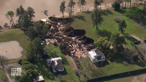 A farm north of Sydney that was underwater just days ago is now crumbling into an enormous sinkhole.